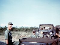 Don Withrow and "Doc" Weiner, Bn Surgeon, ready for the convoy to move out.  Unidentified soldiers in truck behind